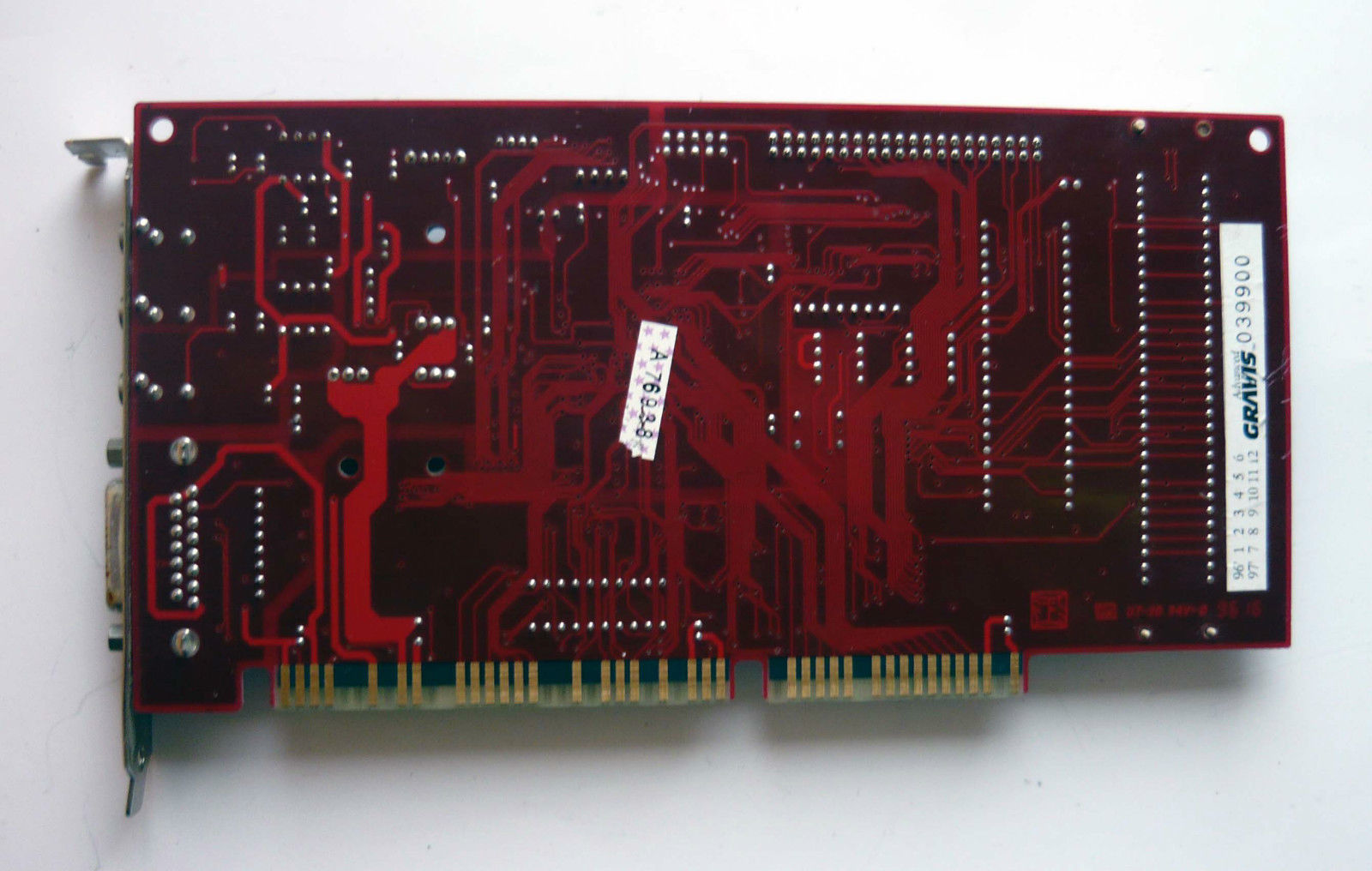 a close up of a red electronic board on a white surface