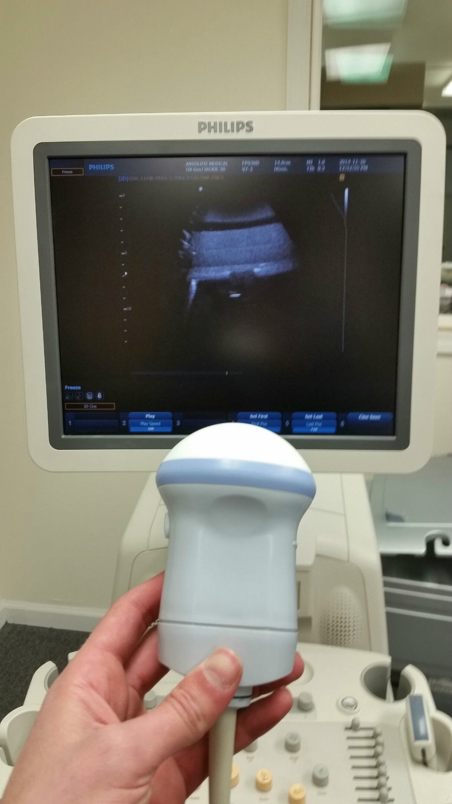 a person holding a device in front of a monitor