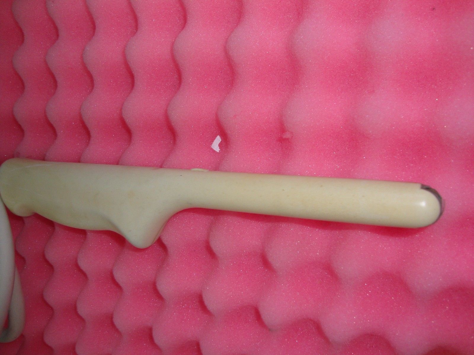 a close up of a white probe on a pink surface