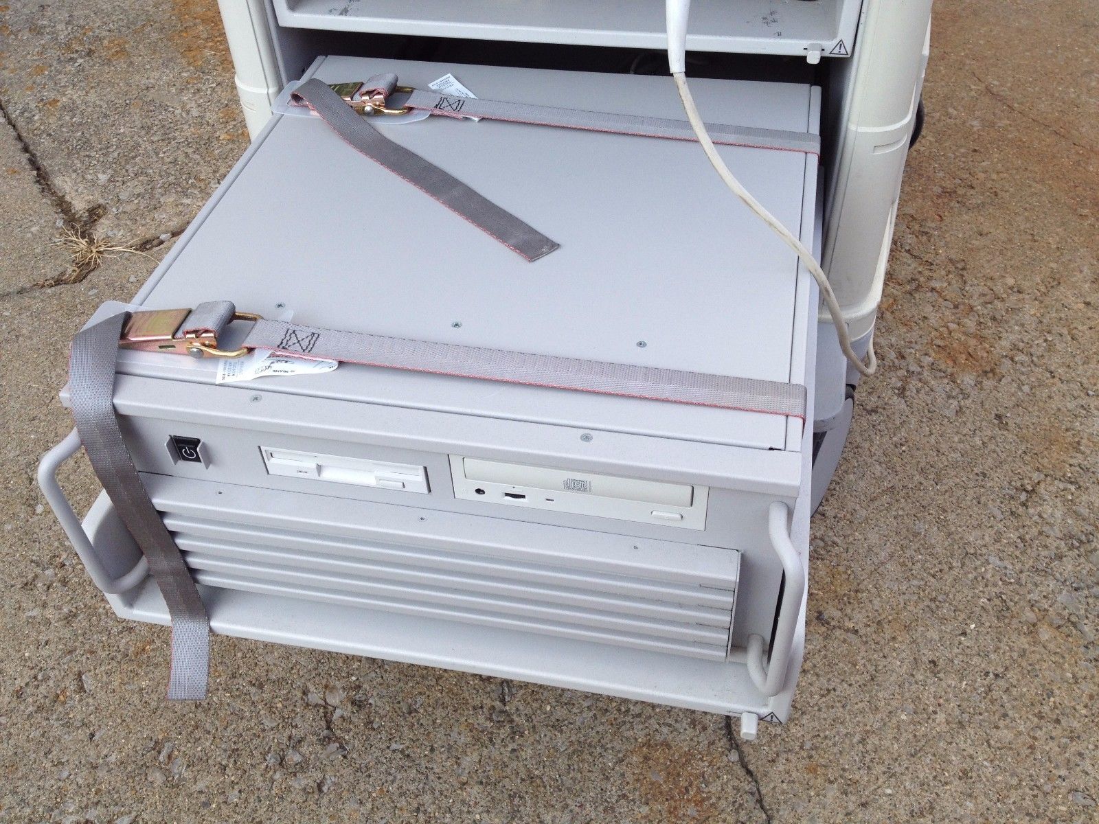 a white computer case sitting on top of a sidewalk