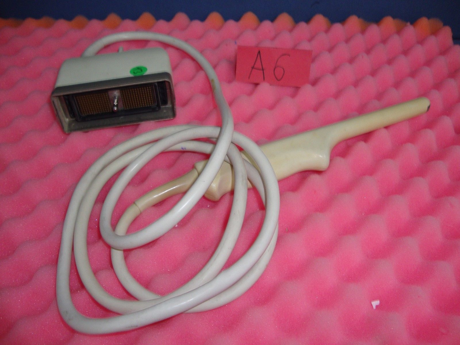 a medical device probe is laying on a pink blanket