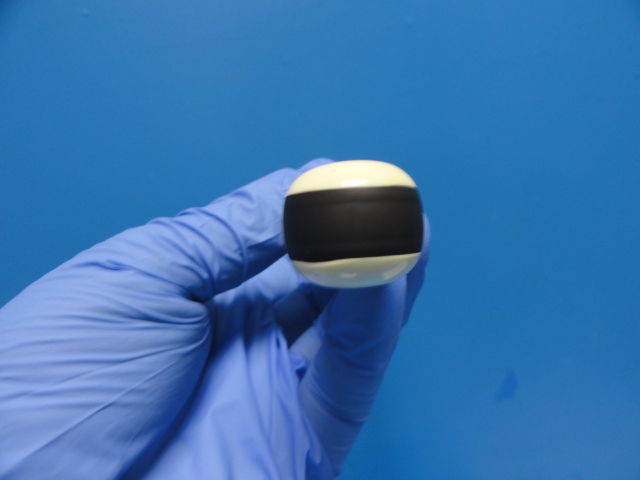 a gloved hand holding a black and white probe